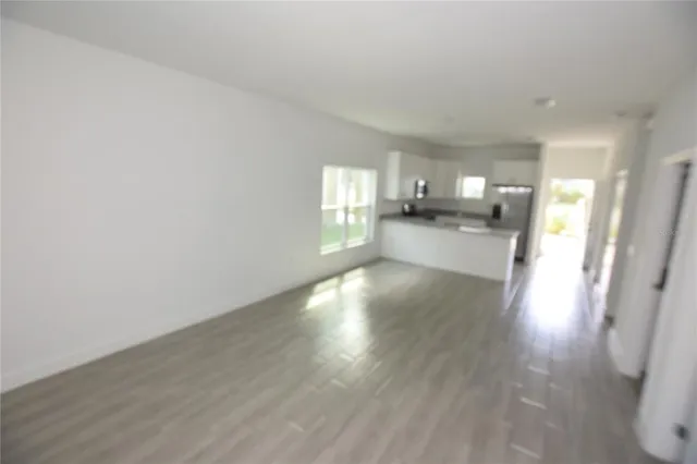 a view of a kitchen with wooden floor and a window