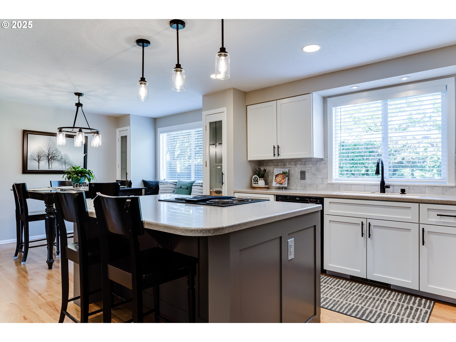 2852 Metolius Drive Eugene, OR 97408 - Photo 17 of 48 a kitchen with stainless steel appliances granite countertop a sink a stove a kitchen island with chairs and white cabinets