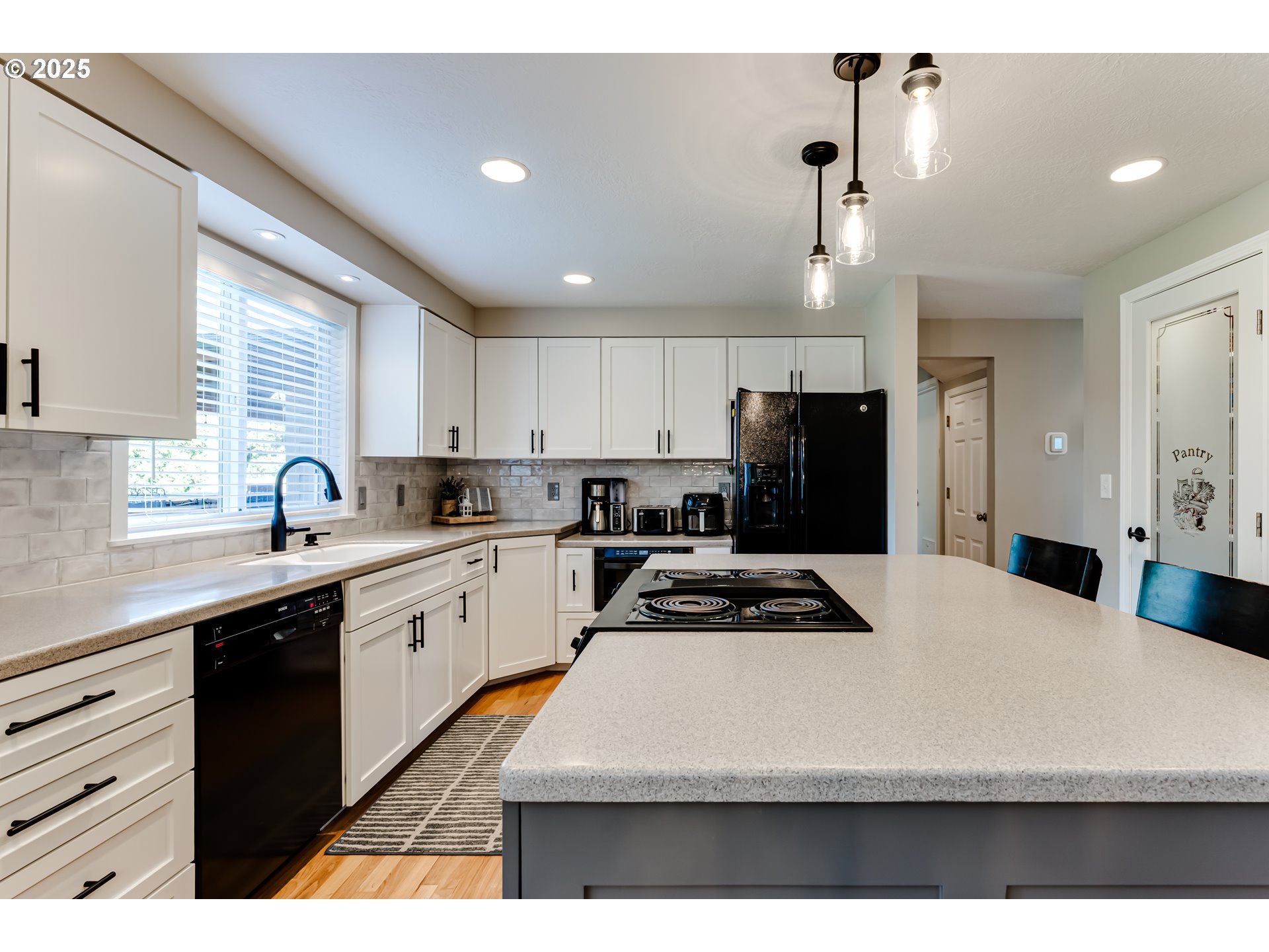 2852 Metolius Drive Eugene, OR 97408 - Photo 19 of 48 a kitchen with kitchen island white cabinets and refrigerator