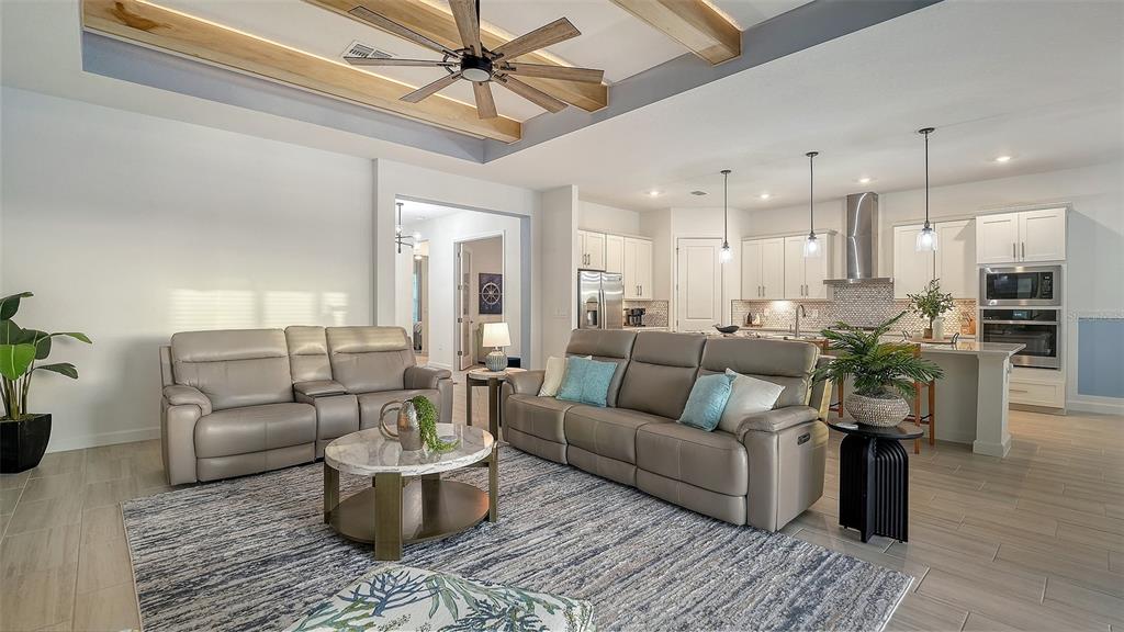 5612 Lightning Whelk Lane Lakewood Ranch, FL 34211 - Photo 18 of 44 a living room with furniture and a dining table with wooden floor