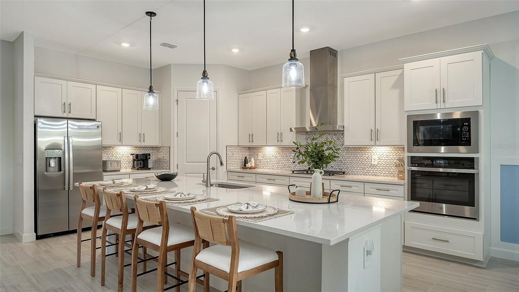 5612 Lightning Whelk Lane Lakewood Ranch, FL 34211 - Photo 19 of 44 a kitchen with stainless steel appliances granite countertop a sink a stove a oven a counter space and cabinets