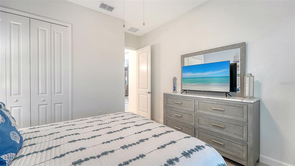 5612 Lightning Whelk Lane Lakewood Ranch, FL 34211 - Photo 33 of 44 a bedroom with a bed and a flat screen tv