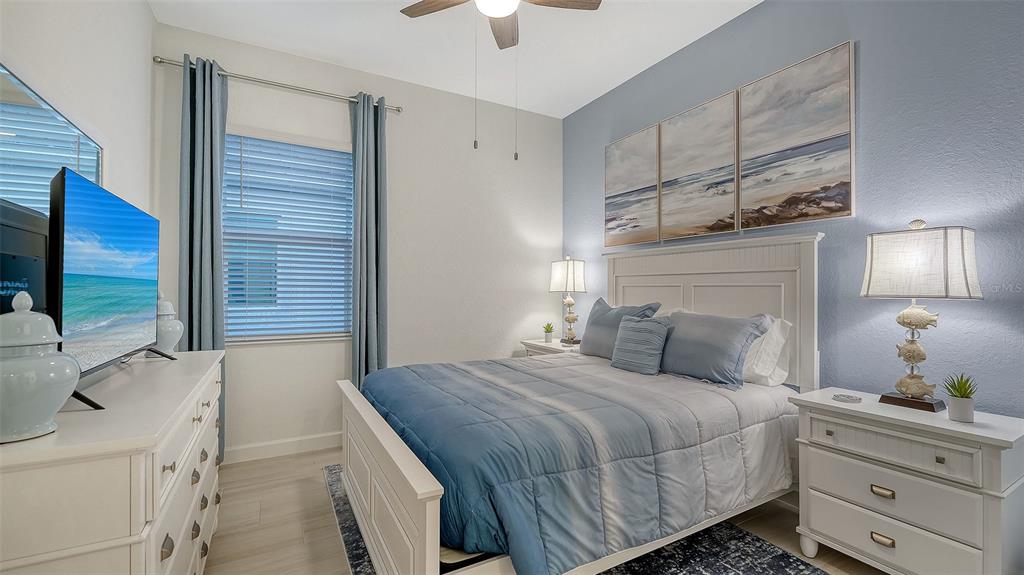 5612 Lightning Whelk Lane Lakewood Ranch, FL 34211 - Photo 35 of 44 a bedroom with a bed and a chandelier