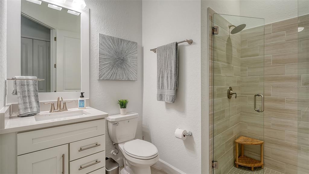5612 Lightning Whelk Lane Lakewood Ranch, FL 34211 - Photo 37 of 44 a bathroom with a granite countertop toilet sink and a mirror