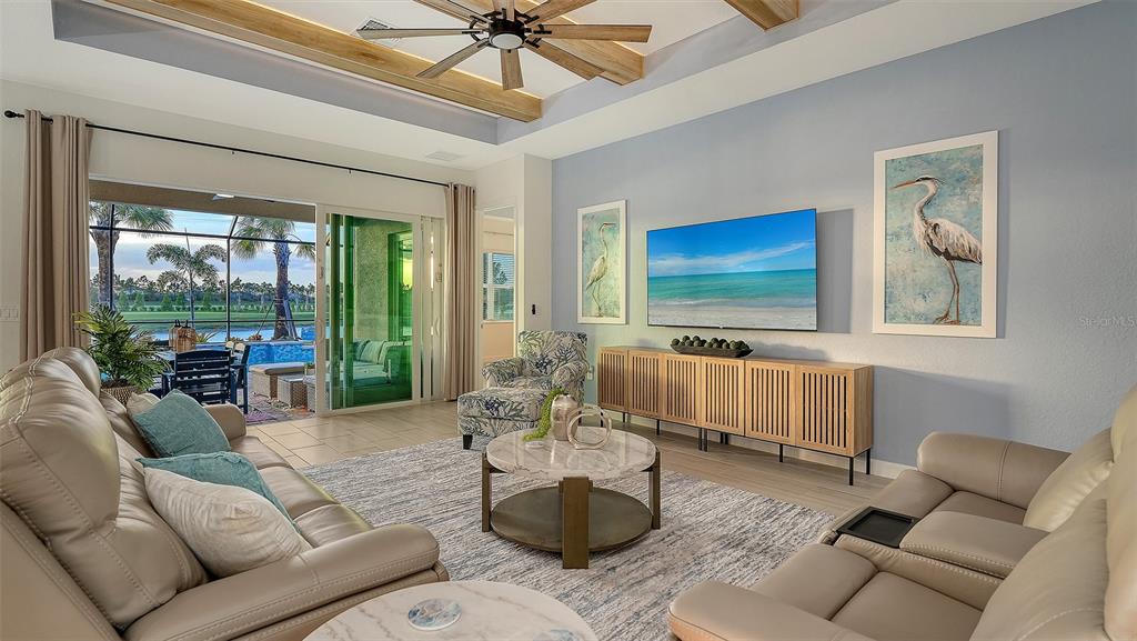 5612 Lightning Whelk Lane Lakewood Ranch, FL 34211 - Photo 10 of 44 a living room with furniture and a flat screen tv