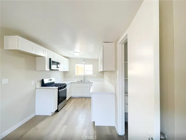 a kitchen with a refrigerator and a stove top oven