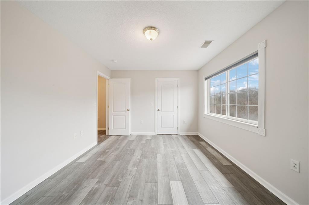 700 Hidden Ridge Court, Unit 302 South Park, PA 15129 - Photo 16 of 27 a view of an empty room with a window and wooden floor