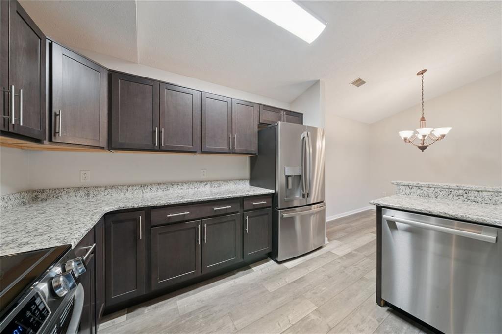 700 Hidden Ridge Court, Unit 302 South Park, PA 15129 - Photo 5 of 27 a kitchen with stainless steel appliances granite countertop a refrigerator a stove and a sink with wooden cabinets
