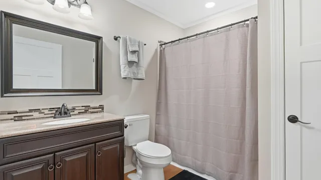 a bathroom with a sink a toilet a mirror and shower curtain