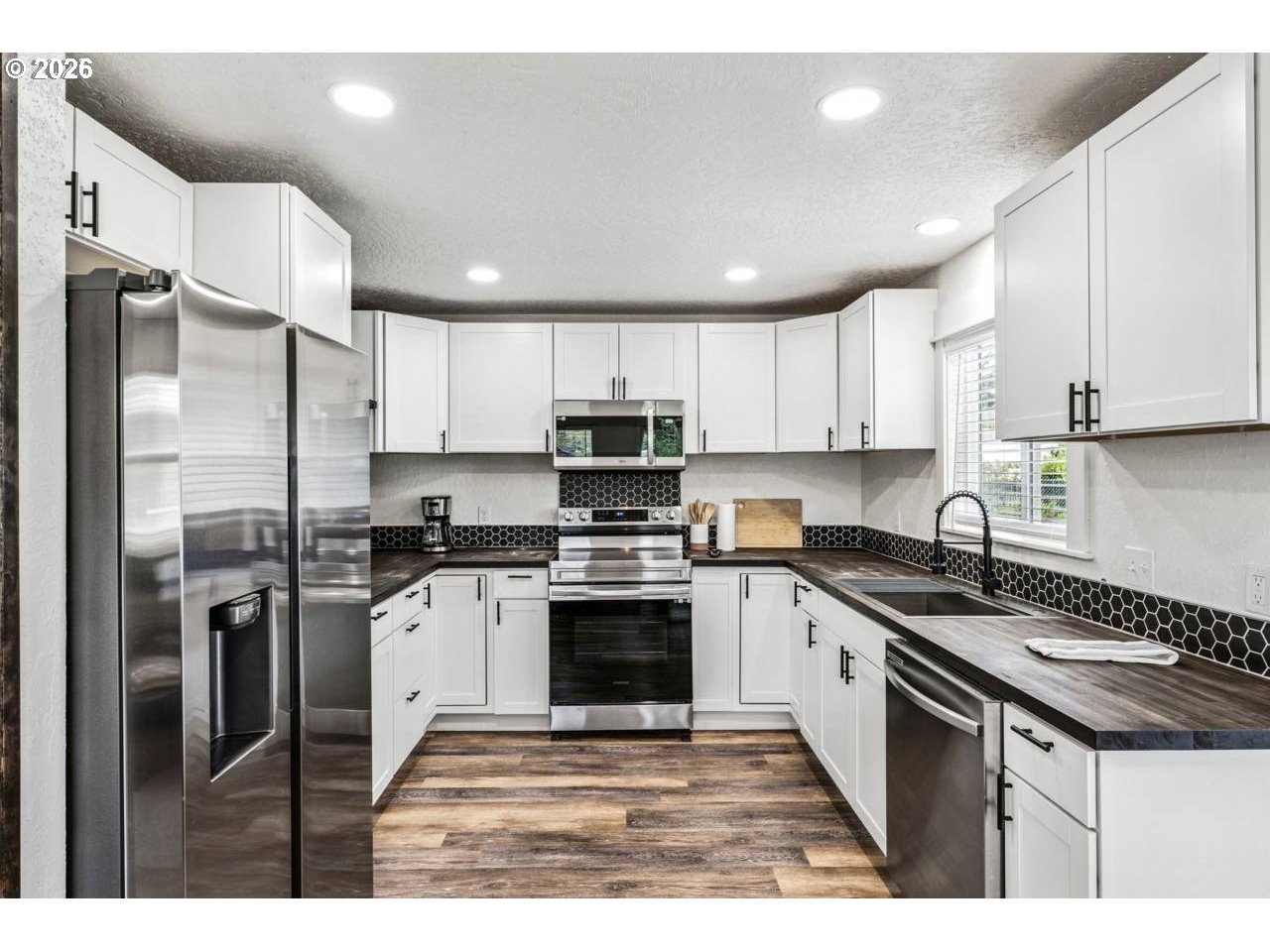 1184 2nd Street Florence, OR 97439 - Photo 14 of 44 a kitchen with stainless steel appliances granite countertop a stove top oven a refrigerator and a sink