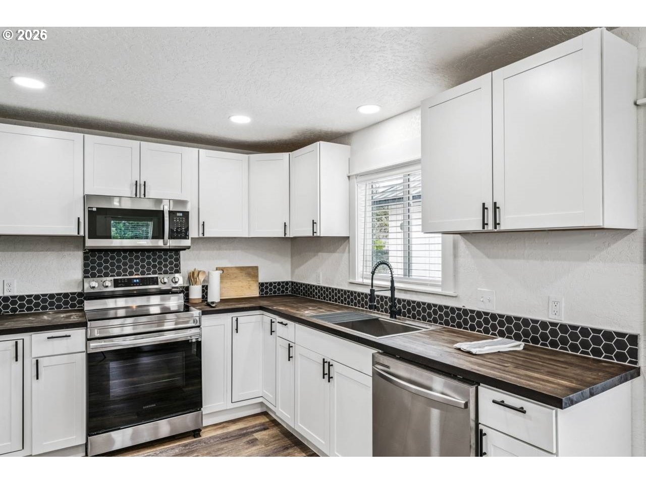 1184 2nd Street Florence, OR 97439 - Photo 15 of 44 a kitchen with granite countertop a sink a stove and cabinets