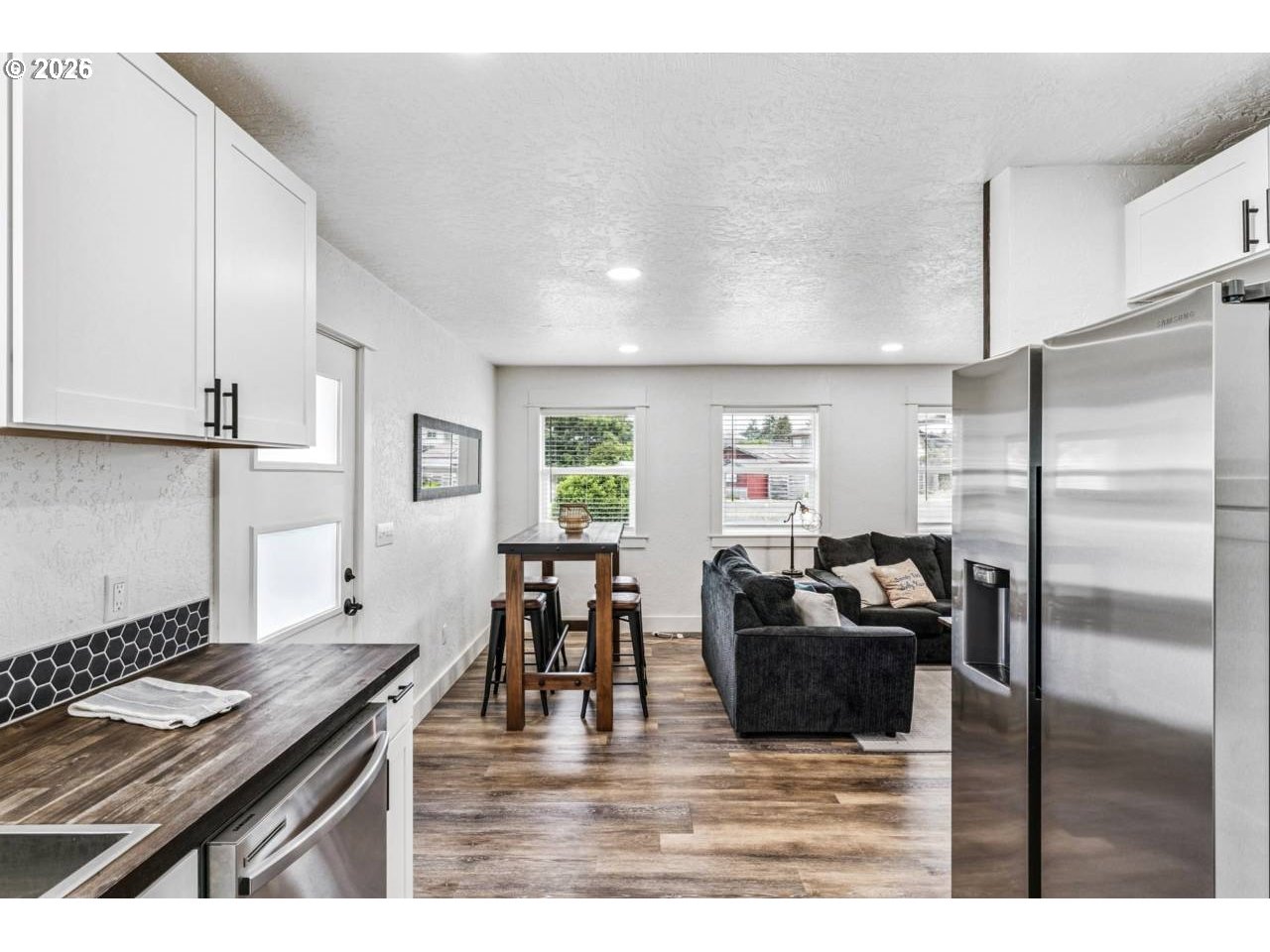 1184 2nd Street Florence, OR 97439 - Photo 17 of 44 a kitchen with stainless steel appliances kitchen island granite countertop a refrigerator a stove a sink and white cabinets with wooden floor