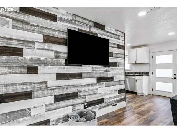 a living room with stainless steel appliances kitchen island a table and chairs in it