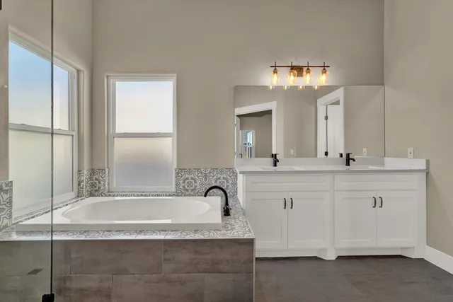a bathroom with a granite countertop bathtub sink and mirror