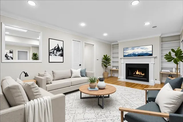 a living room with furniture a fireplace and paintings on the wall