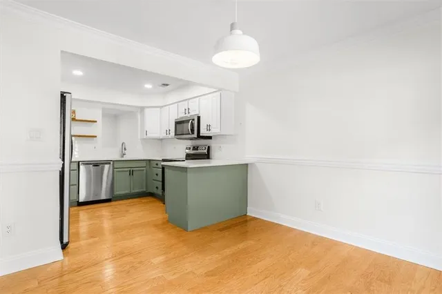 a kitchen with a refrigerator and white cabinets