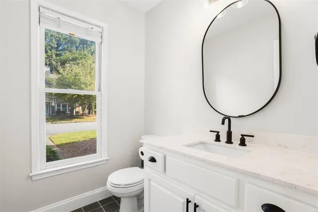 a bathroom with a sink mirror and a toilet