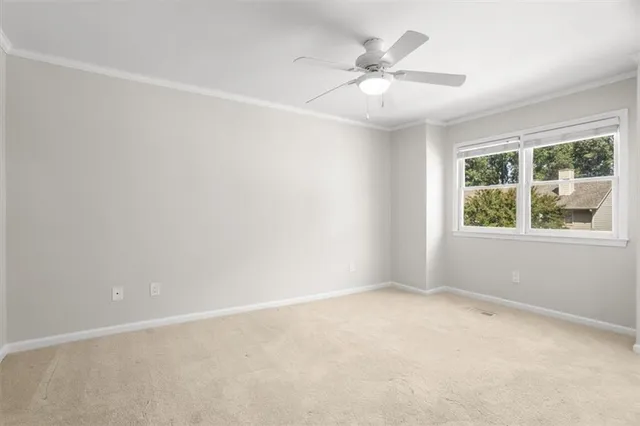 an empty room with a window and a fan