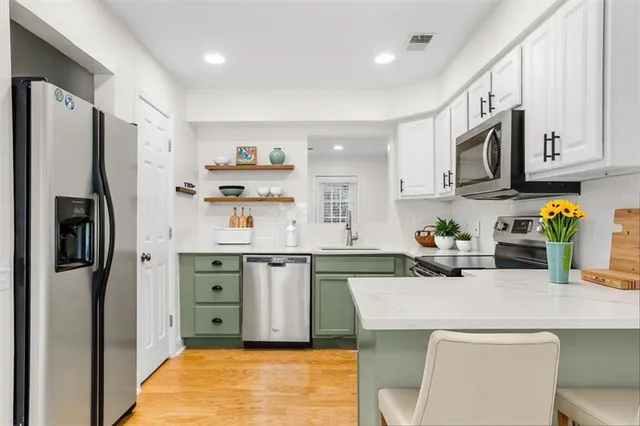 a kitchen with stainless steel appliances a sink stove refrigerator and cabinets