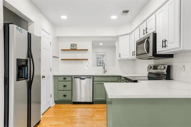 a kitchen with stainless steel appliances granite countertop a refrigerator stove microwave and sink