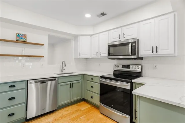 a kitchen with granite countertop a sink and steel appliances