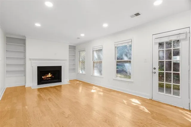 a view of an empty room with a window and a fireplace
