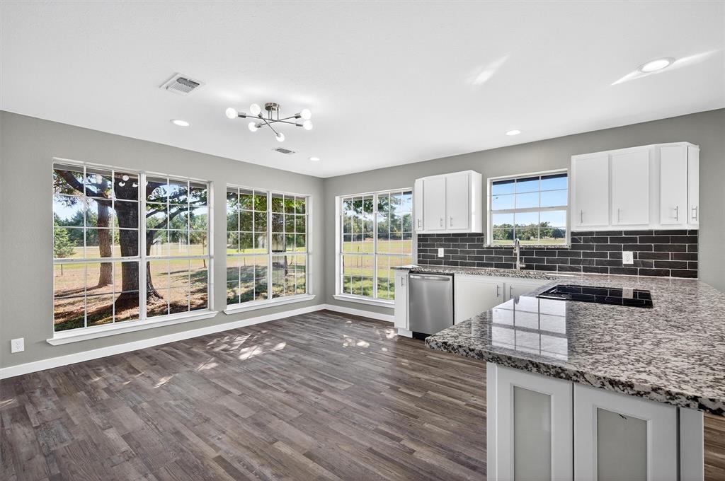 5023 West Line Road Whitesboro, TX 76273 - Photo 17 of 40 a kitchen with granite countertop counter top space a sink appliances and cabinets