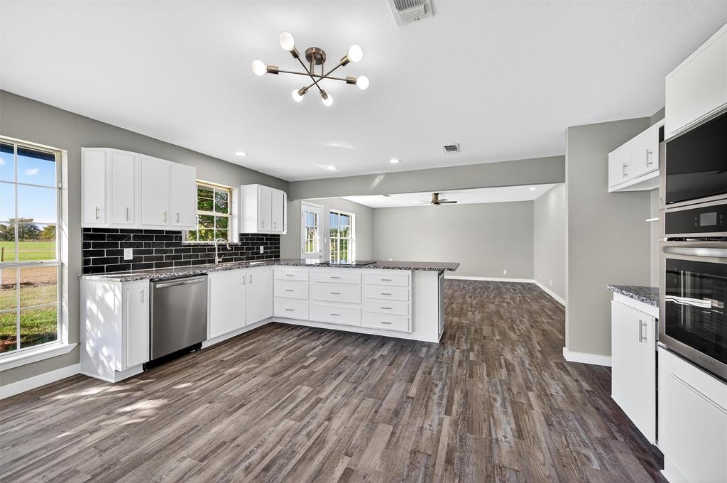 5023 West Line Road Whitesboro, TX 76273 - Photo 19 of 40 a kitchen with cabinets wooden floor and stainless steel appliances