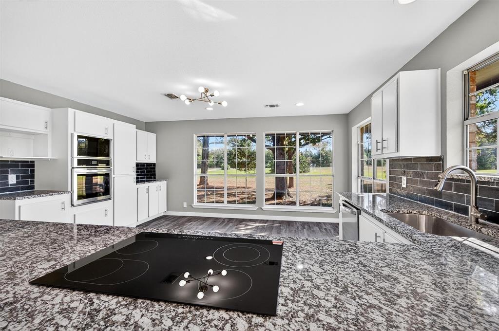 5023 West Line Road Whitesboro, TX 76273 - Photo 20 of 40 a kitchen with granite countertop a stove and a sink