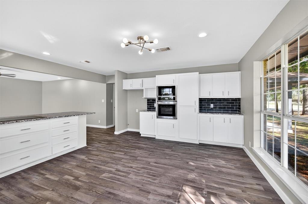 5023 West Line Road Whitesboro, TX 76273 - Photo 21 of 40 a view of kitchen with stainless steel appliances kitchen island wooden floors and white cabinets