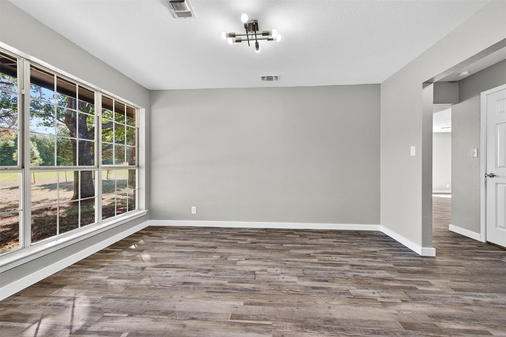 5023 West Line Road Whitesboro, TX 76273 - Photo 22 of 40 a view of an empty room with wooden floor and a window
