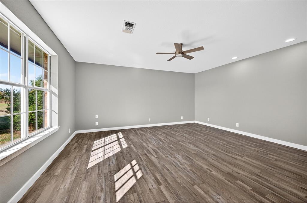 5023 West Line Road Whitesboro, TX 76273 - Photo 23 of 40 a view of an empty room with wooden floor and a window