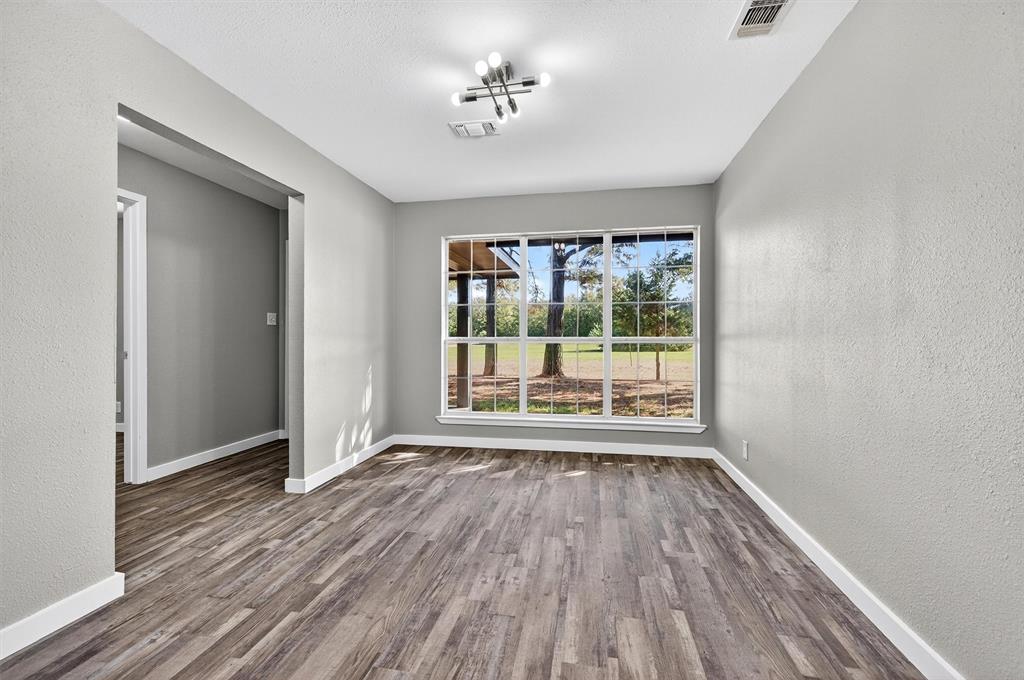 5023 West Line Road Whitesboro, TX 76273 - Photo 24 of 40 a view of an empty room with wooden floor and a window