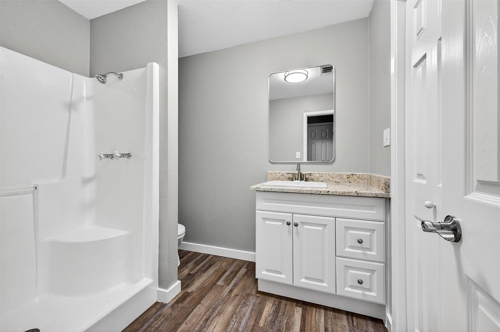 5023 West Line Road Whitesboro, TX 76273 - Photo 29 of 40 a bathroom with a granite countertop sink a mirror and a bathtub