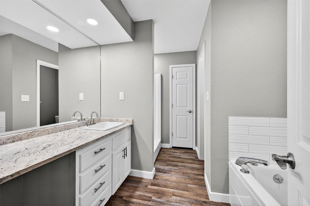 5023 West Line Road Whitesboro, TX 76273 - Photo 34 of 40 a spacious bathroom with a granite countertop sink and a mirror