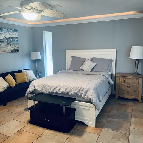 a bedroom with a bed and a lamp on dresser