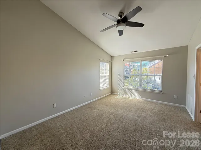 an empty room with a window and a fan