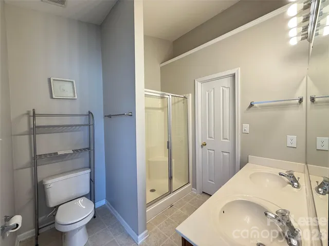 a spacious bathroom with a granite countertop toilet a sink and a mirror