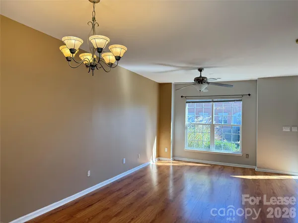 a view of a room with wooden floor and chandelier