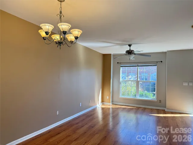 a view of a room with wooden floor and chandelier