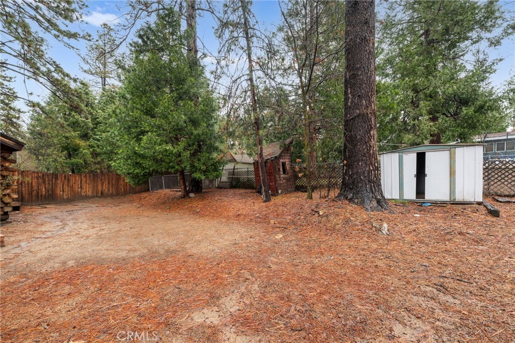 53645 Country Club Drive Idyllwild, CA 92549 - Photo 29 of 33 a backyard of a house with large trees and wooden fence