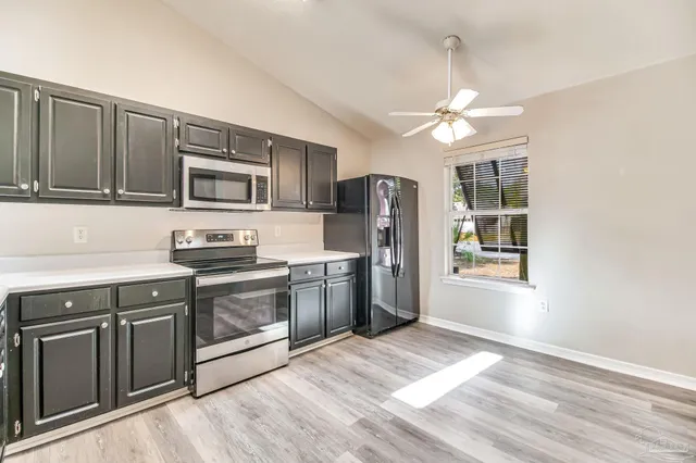 a kitchen with stainless steel appliances granite countertop a stove a refrigerator and a microwave