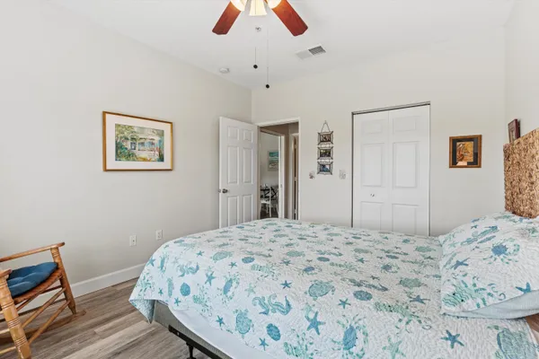 a bedroom with a bed a chair and a large window