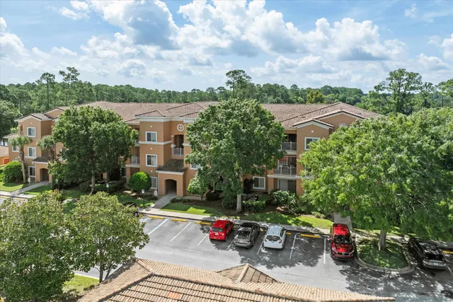 a view of street with flower plants and wooden fence