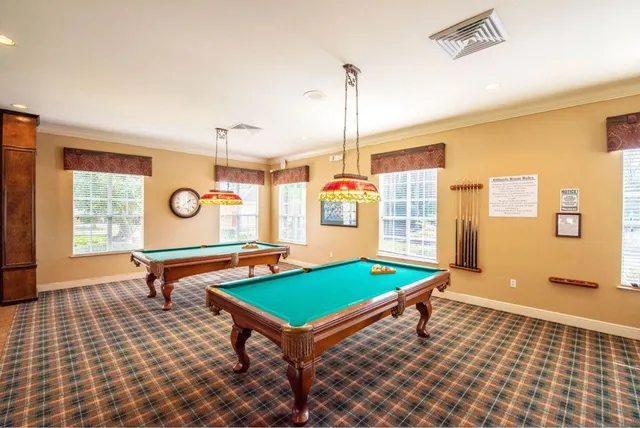 a room with pool table and windows