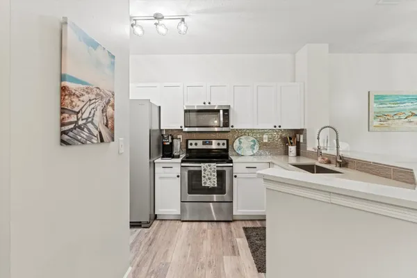 a kitchen with stainless steel appliances a stove a sink and a refrigerator