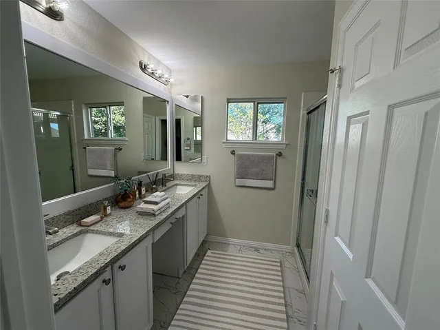 a bathroom with a double vanity sink and mirror