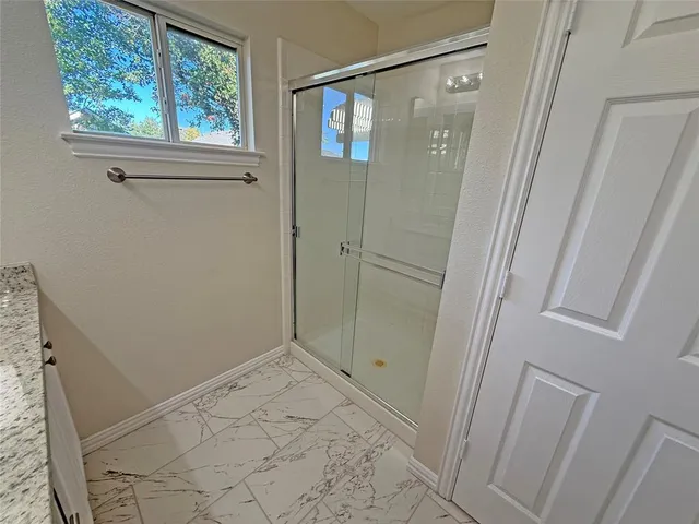 a kitchen with stainless steel appliances granite countertop a stove a sink a refrigerator a microwave and white cabinets