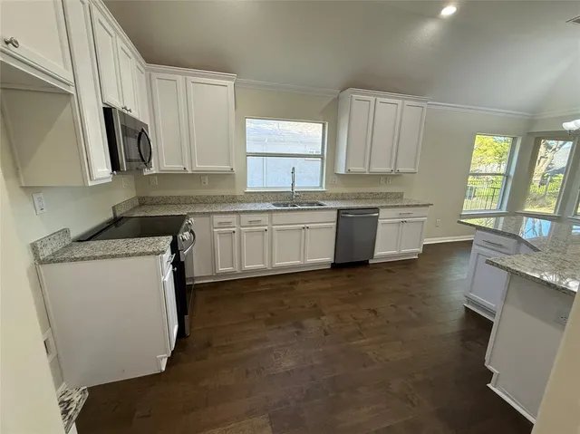 a kitchen with a sink stove and cabinets