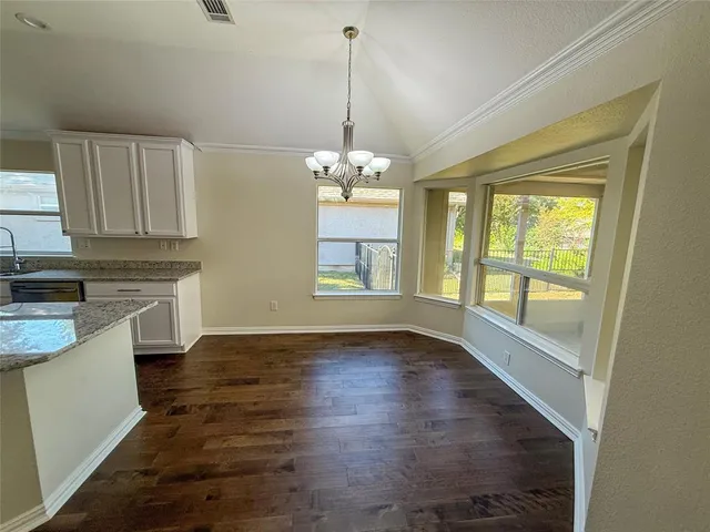 a view of a kitchen with a stove wooden floor and a window